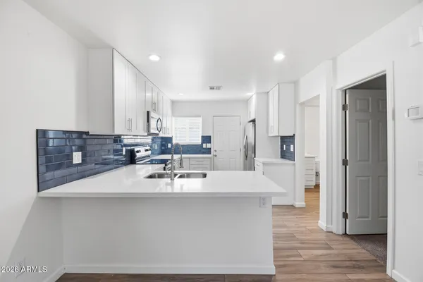a large kitchen with kitchen island a sink stainless steel appliances and cabinets