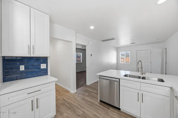 a kitchen with a sink cabinets and wooden floor