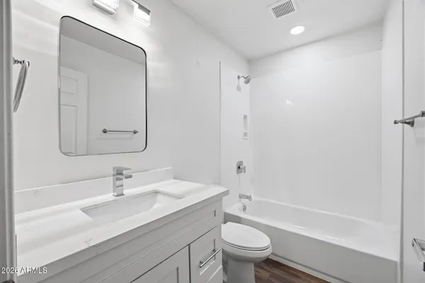 a bathroom with a sink a toilet and a large mirror