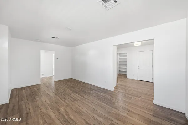 a view of an empty room with wooden floor