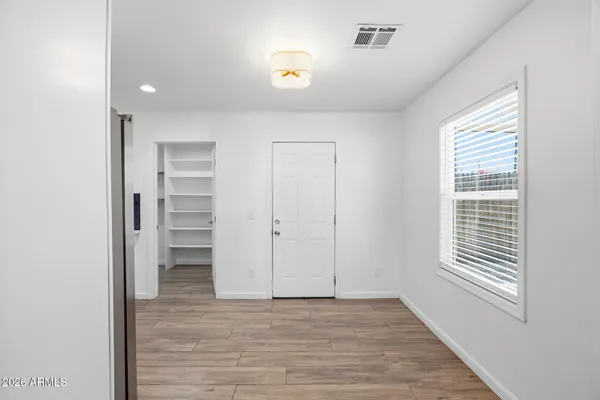 a view of empty room with wooden floor and fan