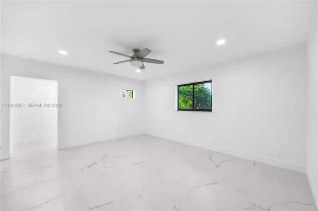 an empty room with a ceiling fan and a window