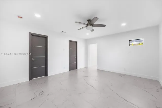 an empty room with fan and windows