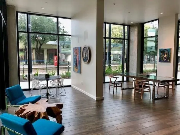 a living room with furniture large window and wooden floor