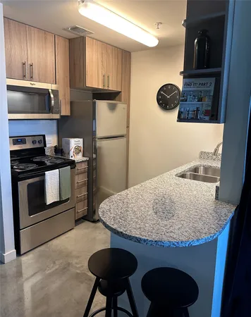 a kitchen with stainless steel appliances granite countertop a stove a refrigerator and a microwave