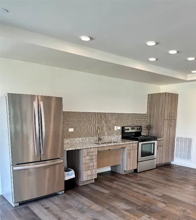 a kitchen with stainless steel appliances a refrigerator and wooden floor