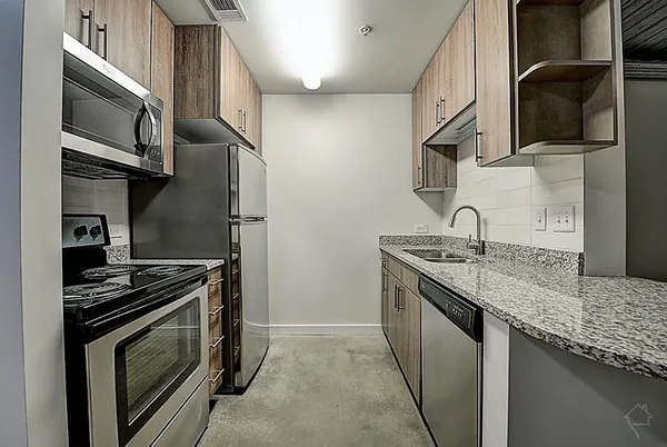 a kitchen with stainless steel appliances granite countertop a sink stove and refrigerator