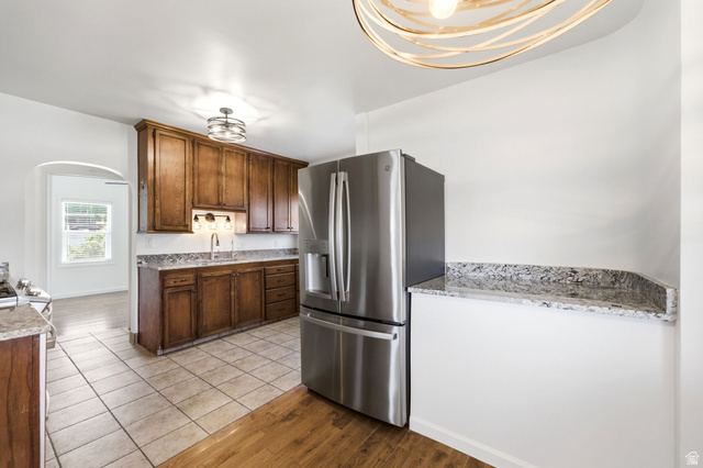 1925 South Main Street Bountiful, UT 84010 - Photo 12 of 48 Kitchen featuring wood cabinetry, stainless steel refrigerator, and granite countertops