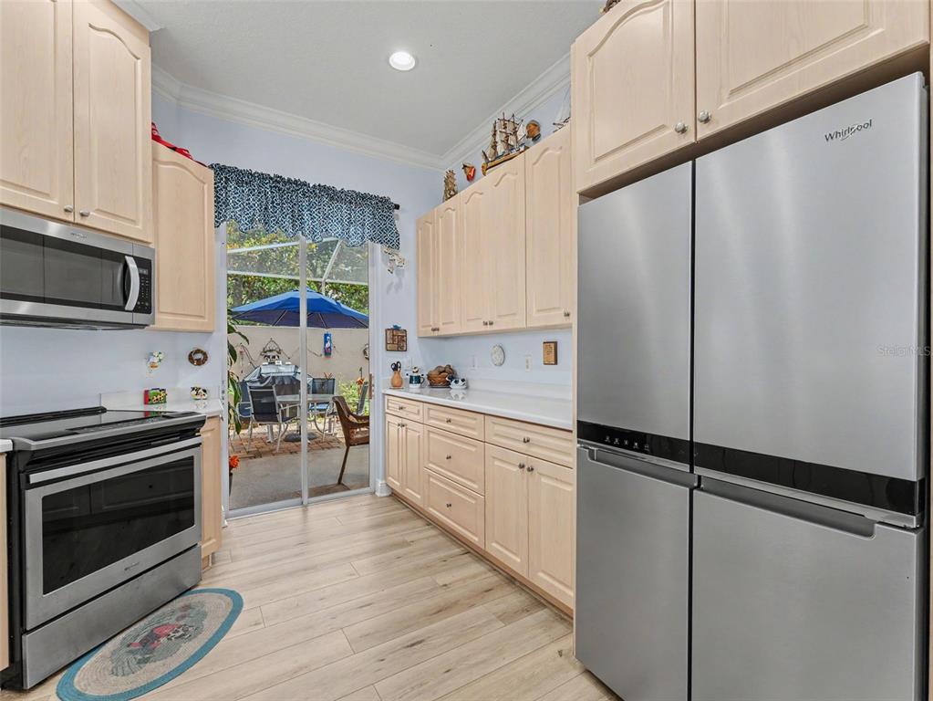 8910 Jericho Road Weeki Wachee, FL 34613 - Photo 27 of 52 a kitchen with stainless steel appliances a refrigerator sink and cabinets