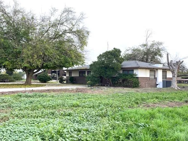a front view of a house with a yard and trees
