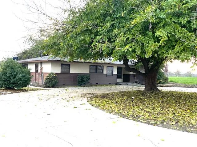 a front view of house with yard and trees around
