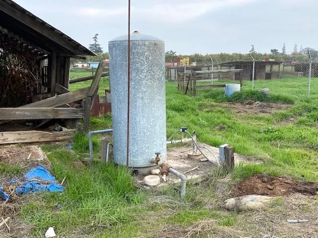 a backyard of a house with barbeque oven table and chairs