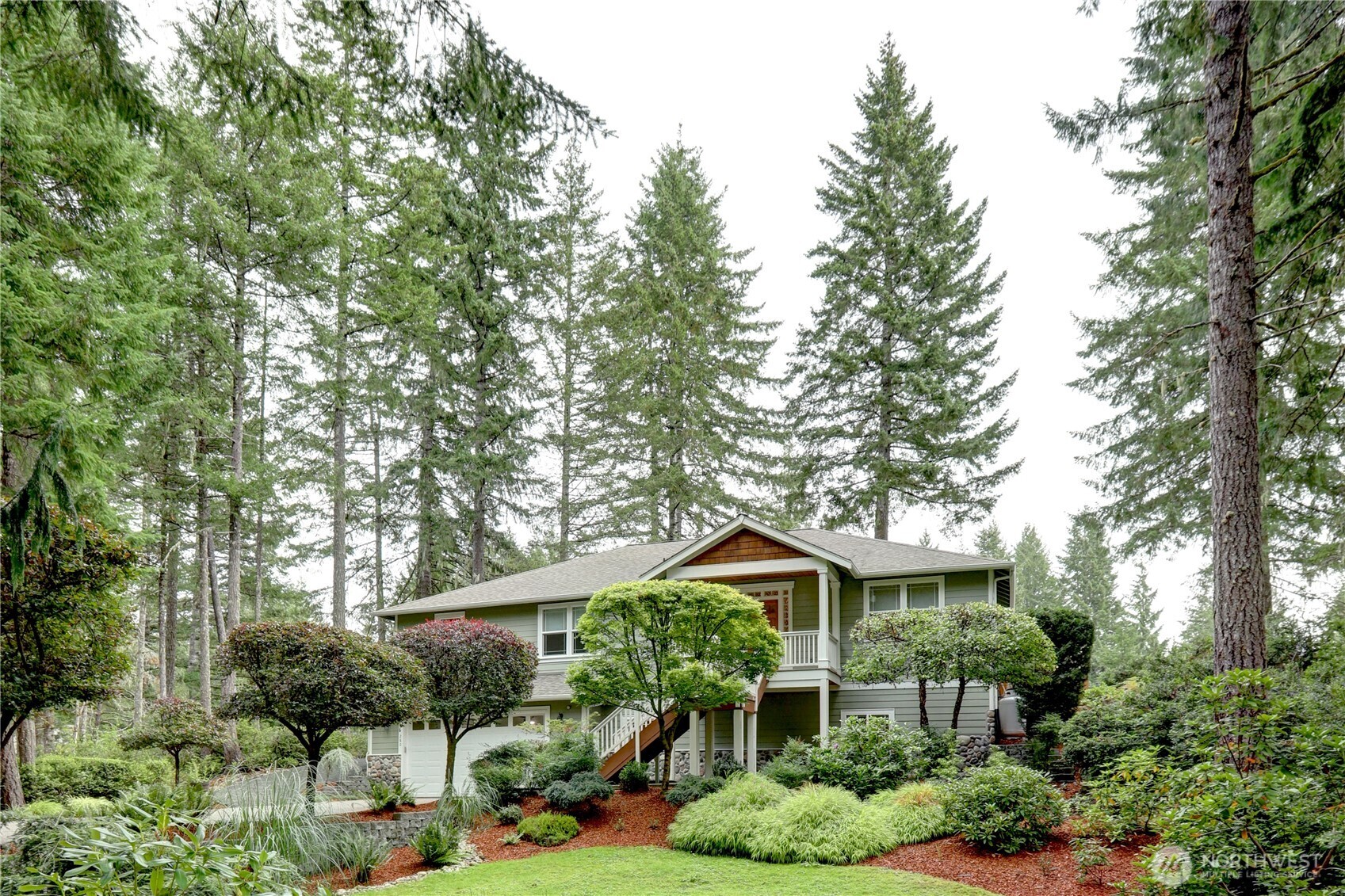 a front view of a house with a yard and potted plants