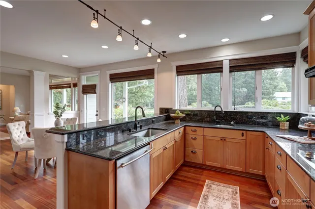 a kitchen with stainless steel appliances granite countertop a sink and wooden cabinets