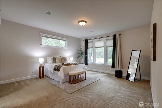 a spacious bedroom with a bed and a large window