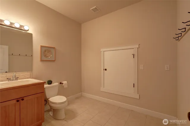 a bathroom with a toilet a sink and mirror