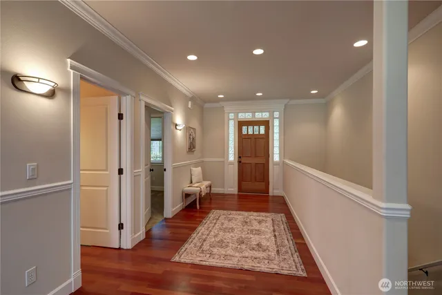 a view of a hallway with wooden floor and staircase