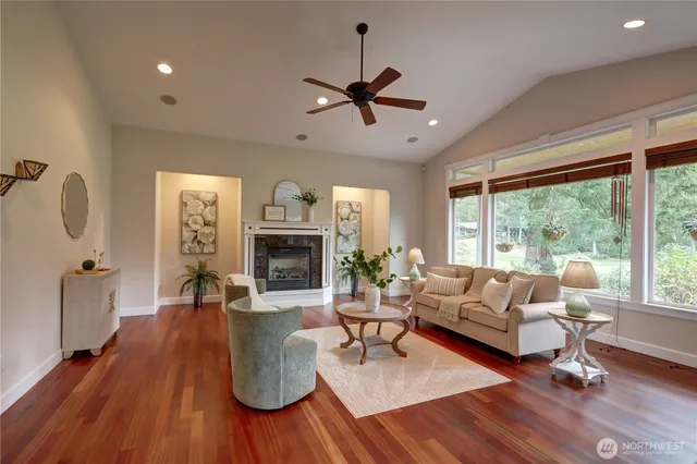 a living room with furniture a fireplace and a floor to ceiling window