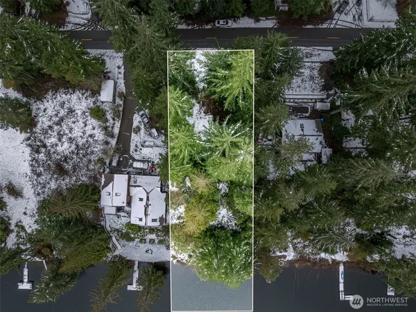 an aerial view of a house with a yard lake and outdoor seating