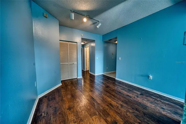 a view of an empty room with wooden floor