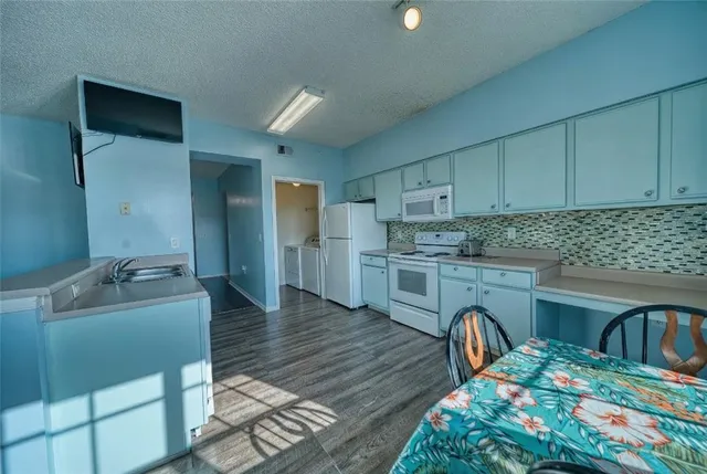 a kitchen that has a sink cabinets counter space and appliances
