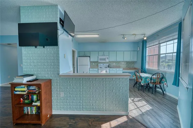 a kitchen with furniture a flat screen tv and a fireplace