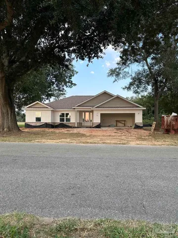 a front view of a house with a garden and trees