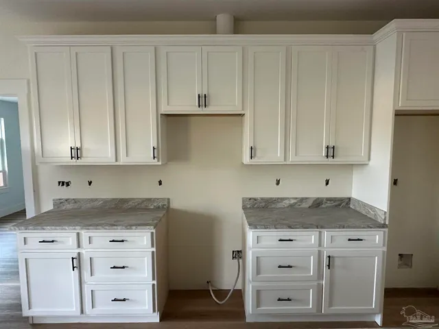 a kitchen with granite countertop white cabinets and white appliances