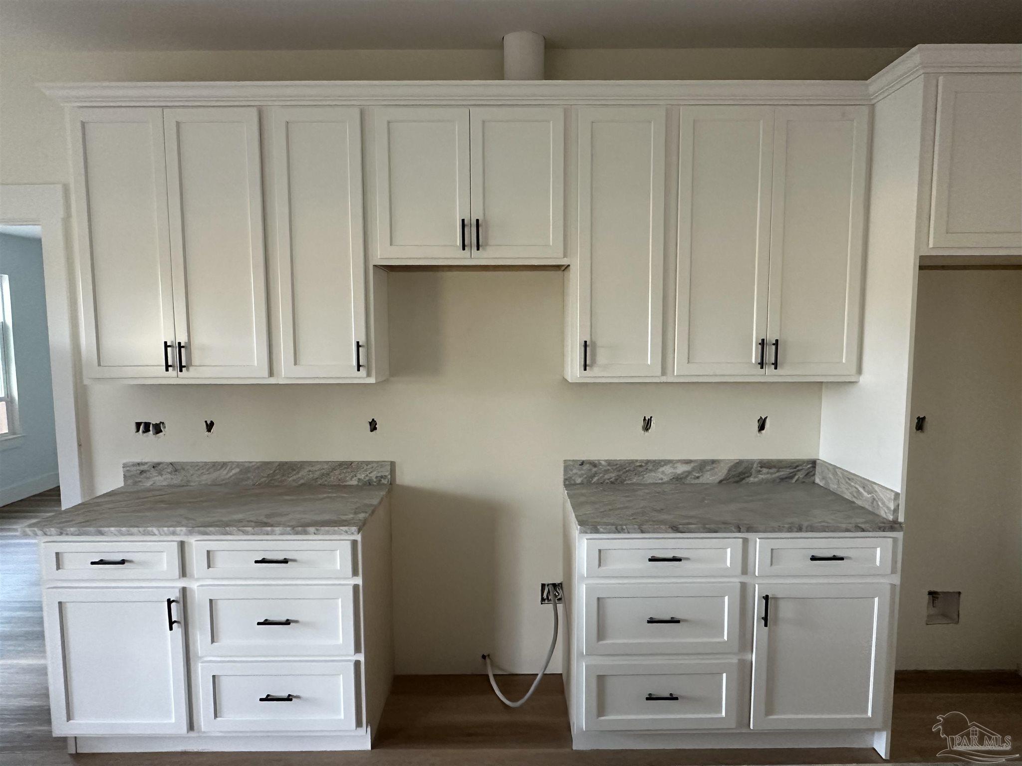 4954 Beck Avenue Jay, FL 32565 - Photo 4 of 9 a kitchen with granite countertop white cabinets and white appliances