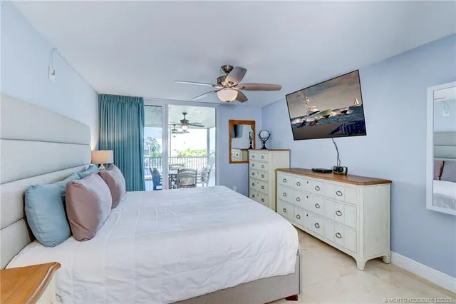a bedroom with a bed and a flat tv screen on dresser