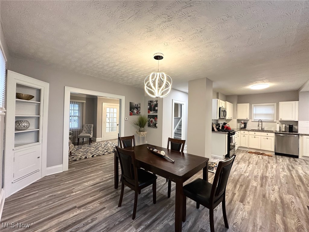 3393 Kildare Road Cleveland, OH 44118 - Photo 5 of 15 Dining space featuring a textured ceiling, built in shelves, dark hardwood / wood-style floors, and sink