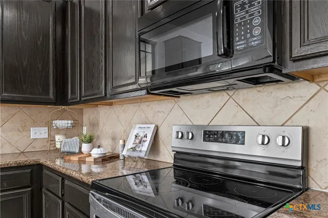 a kitchen with a stove a microwave and cabinets