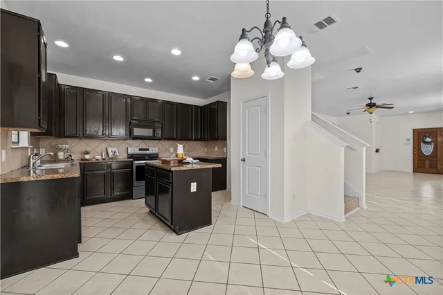 a kitchen with stainless steel appliances granite countertop a refrigerator and a sink