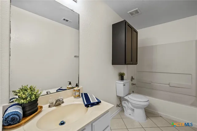 a bathroom with a sink a toilet and mirror