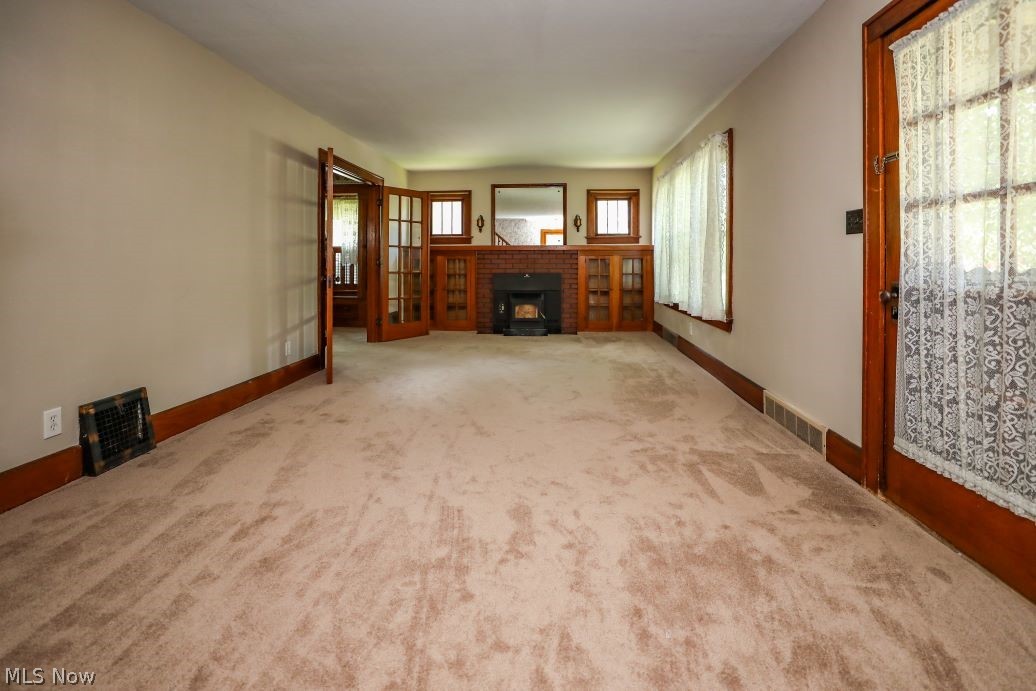 728 East Riddle Avenue Ravenna, OH 44266 - Photo 26 of 40 Unfurnished living room featuring plenty of natural light, a brick fireplace, and carpet flooring