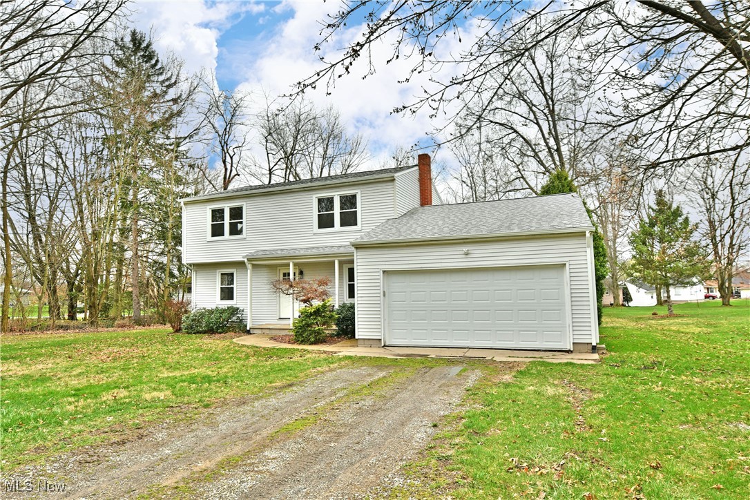 2474 Johnny Cake Road Southeast Warren, OH 44484 - Photo 43 of 50 View of front of property featuring driveway, an attached garage, a chimney, and a front yard