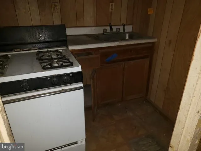 a kitchen with granite countertop a sink stove and cabinets