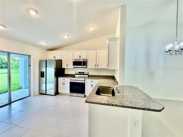 a kitchen with stainless steel appliances granite countertop a stove a sink and a refrigerator