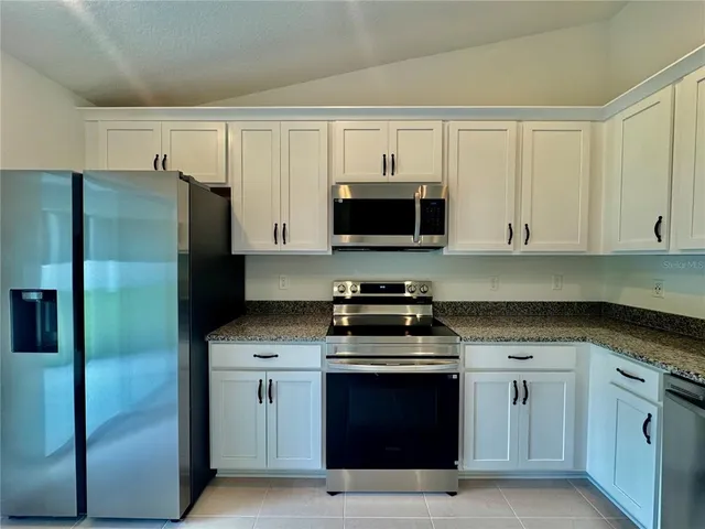 a kitchen with cabinets stainless steel appliances and a counter space