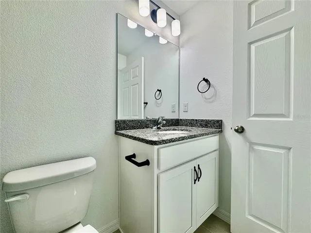 a bathroom with a sink a toilet and mirror