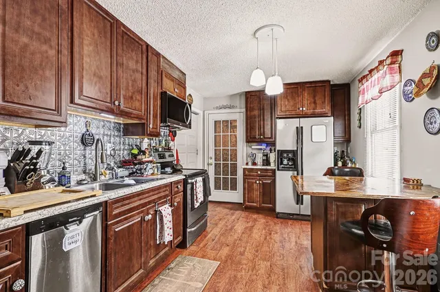 a kitchen with stainless steel appliances granite countertop a stove oven and a refrigerator
