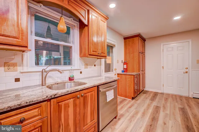 a kitchen with granite countertop a sink and cabinets