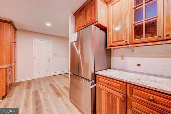 a view of a kitchen with fridge and wooden floor
