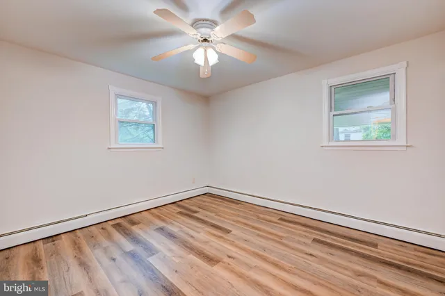 a view of an empty room with a window and a ceiling fan