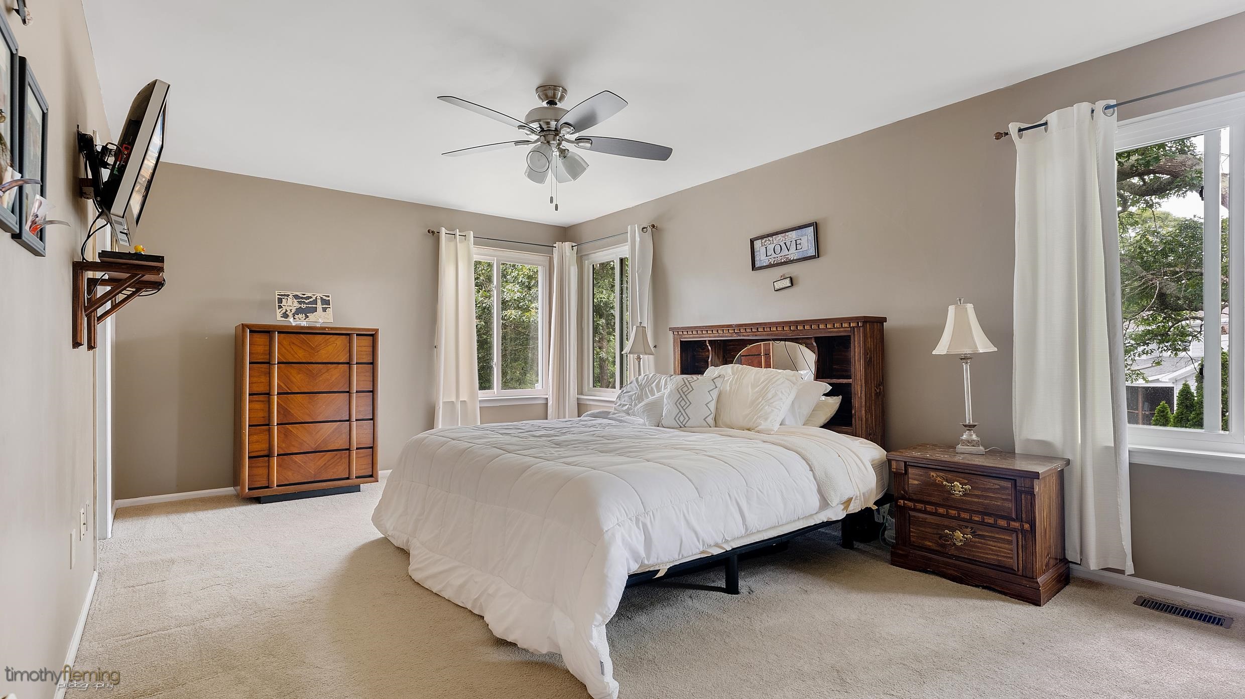 3 Inlet Ocean View, NJ 08230 - Photo 25 of 42 a bedroom with a bed a dresser and a chandelier