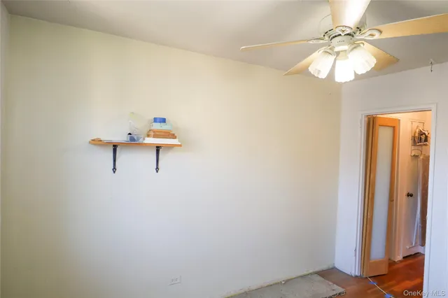 a view of a room with a hanging light and kitchen view