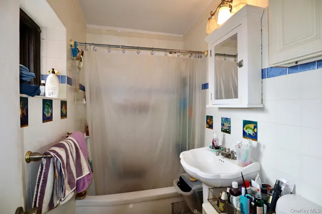 a bathroom with a tub shower sink and toilet