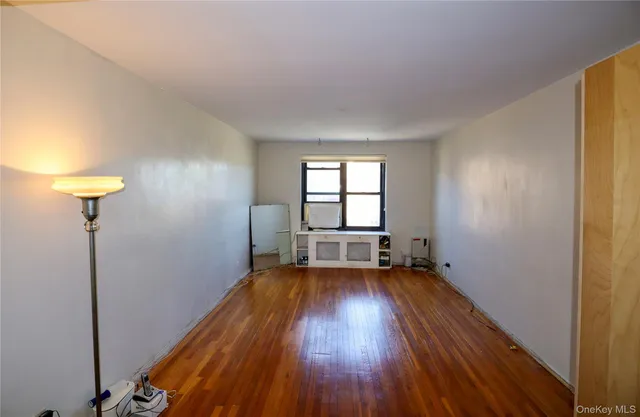 a view of a room with wooden floor and a window