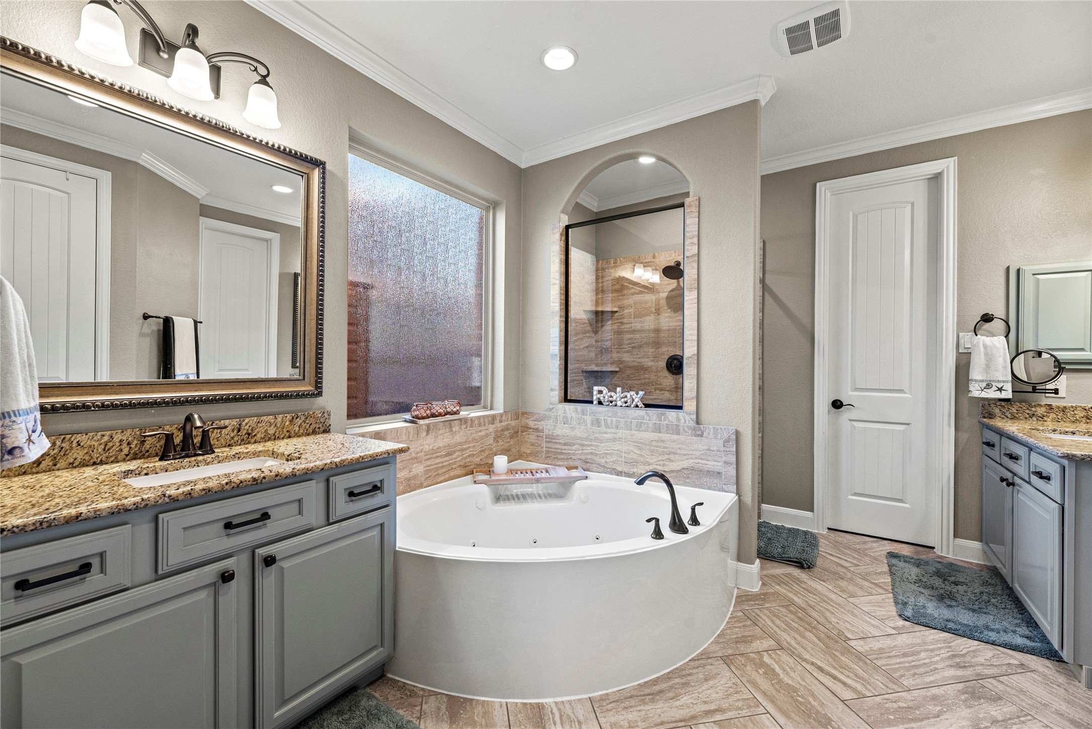 9518 Three Stone Lane Tomball, TX 77375 - Photo 19 of 33 Large and tranquil primary ensuite with a tub, a separate large shower, two vanity spaces and a large closet.