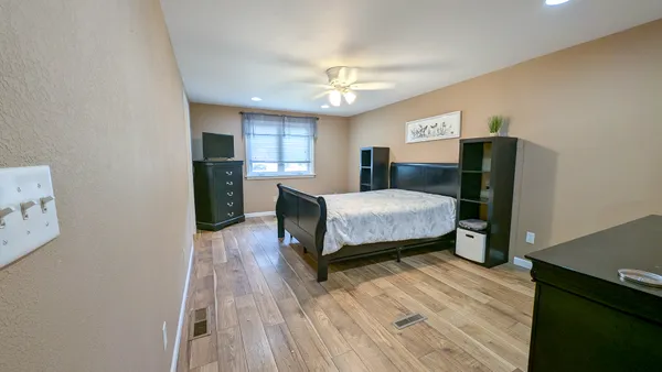 a bedroom with a bed and wooden floor